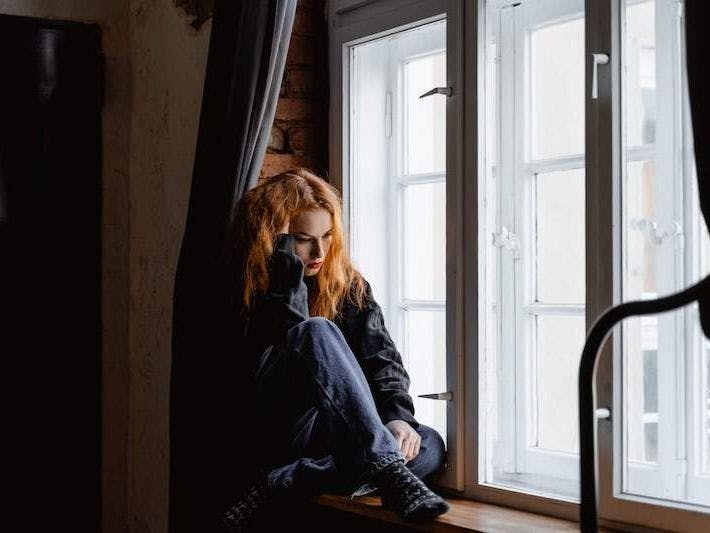 Woman sitting in window sil